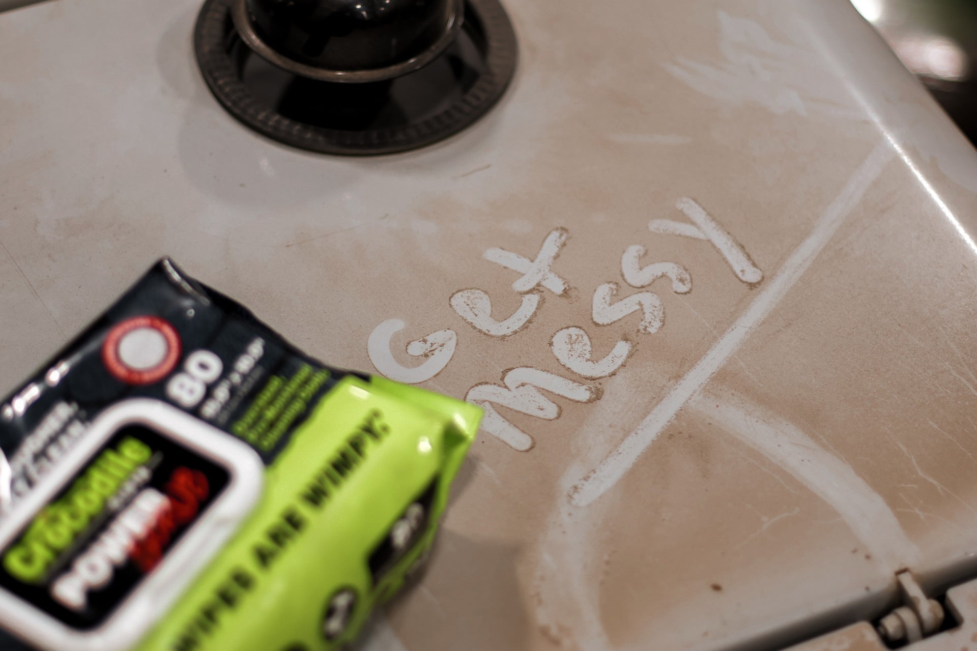 Stove with 'Get Messy' text and a box of cleaning wipes on it