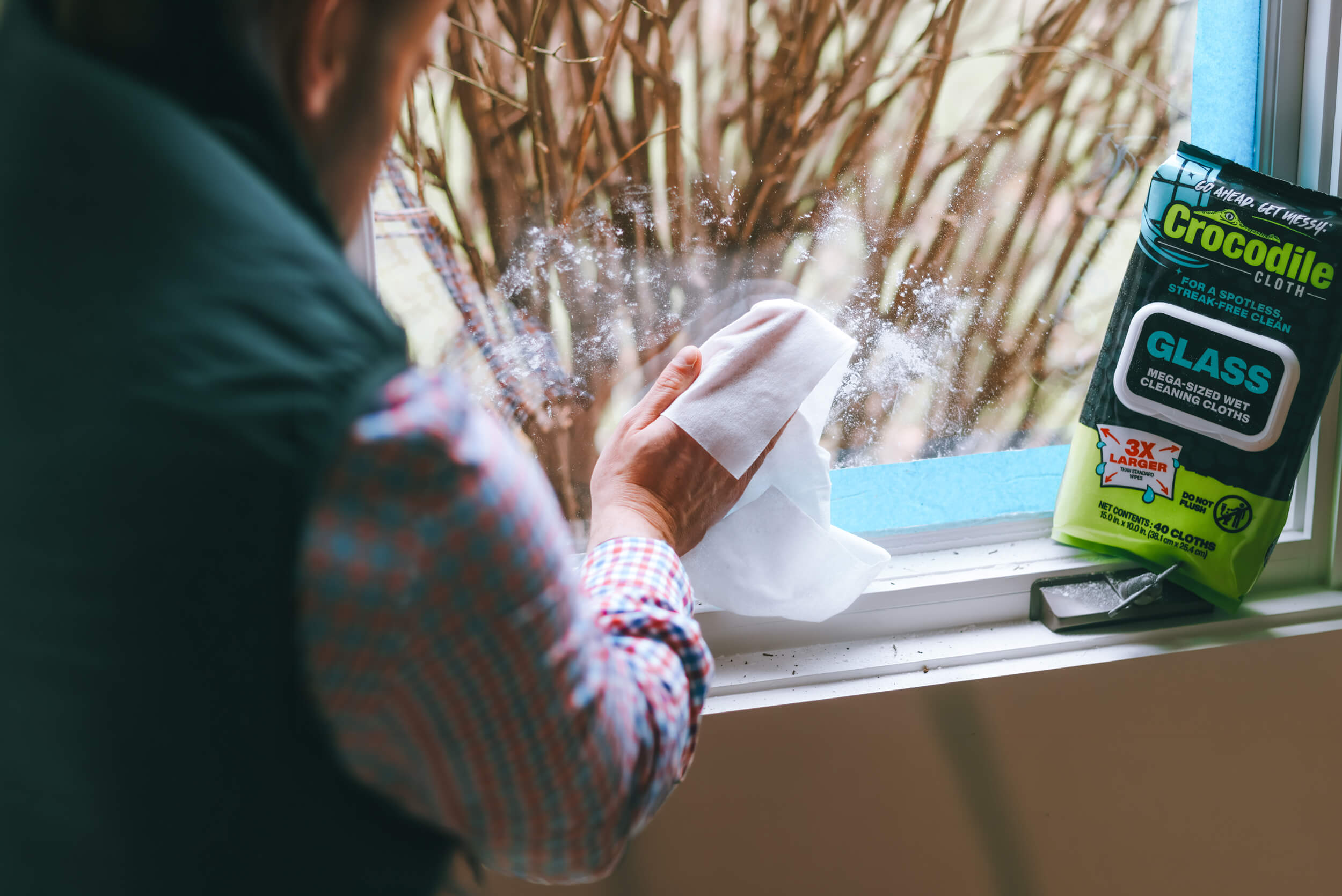 Person cleaning a window with Crocodile Cloth Glass wipe.