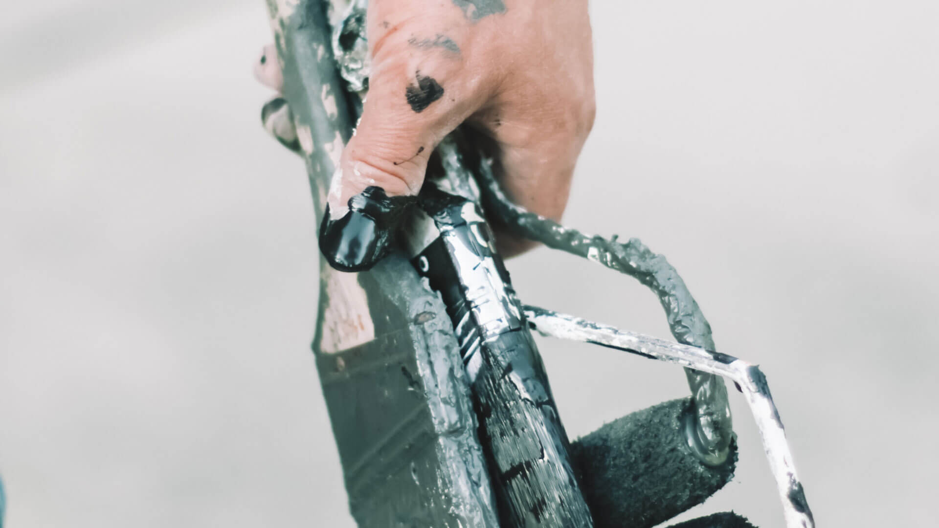 Hand holding dirty paint brushes